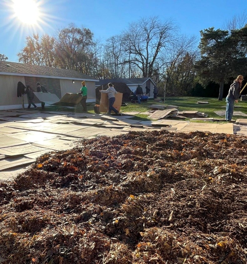 People covering ground with cardboard.